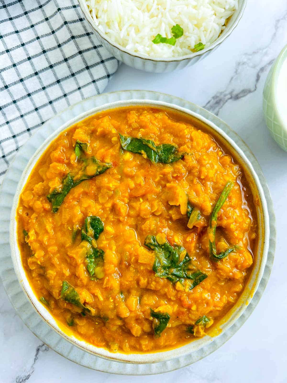 Red lentil dal in a white bowl.