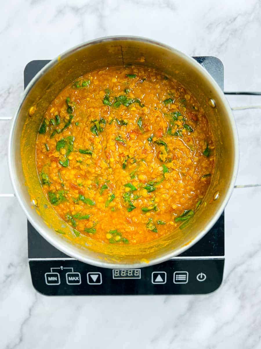Spinach added to the cooked dal.