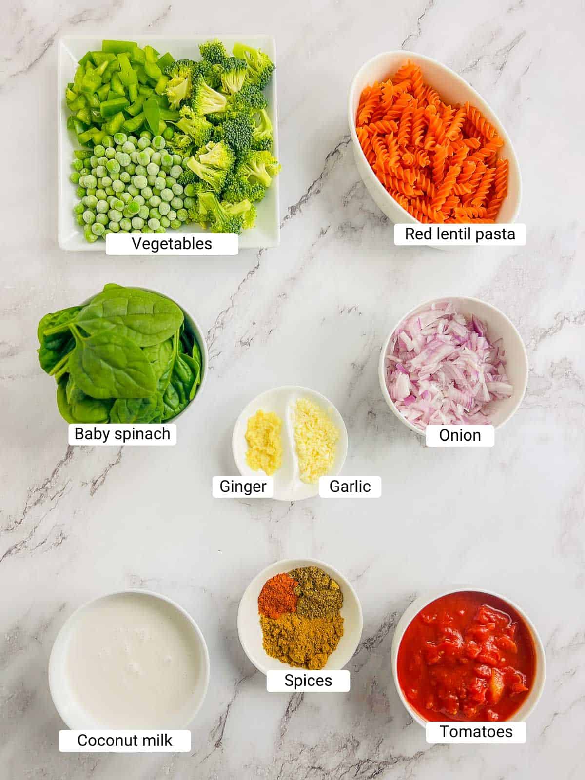 Ingredients to make red lentil pasta on a marble surface.