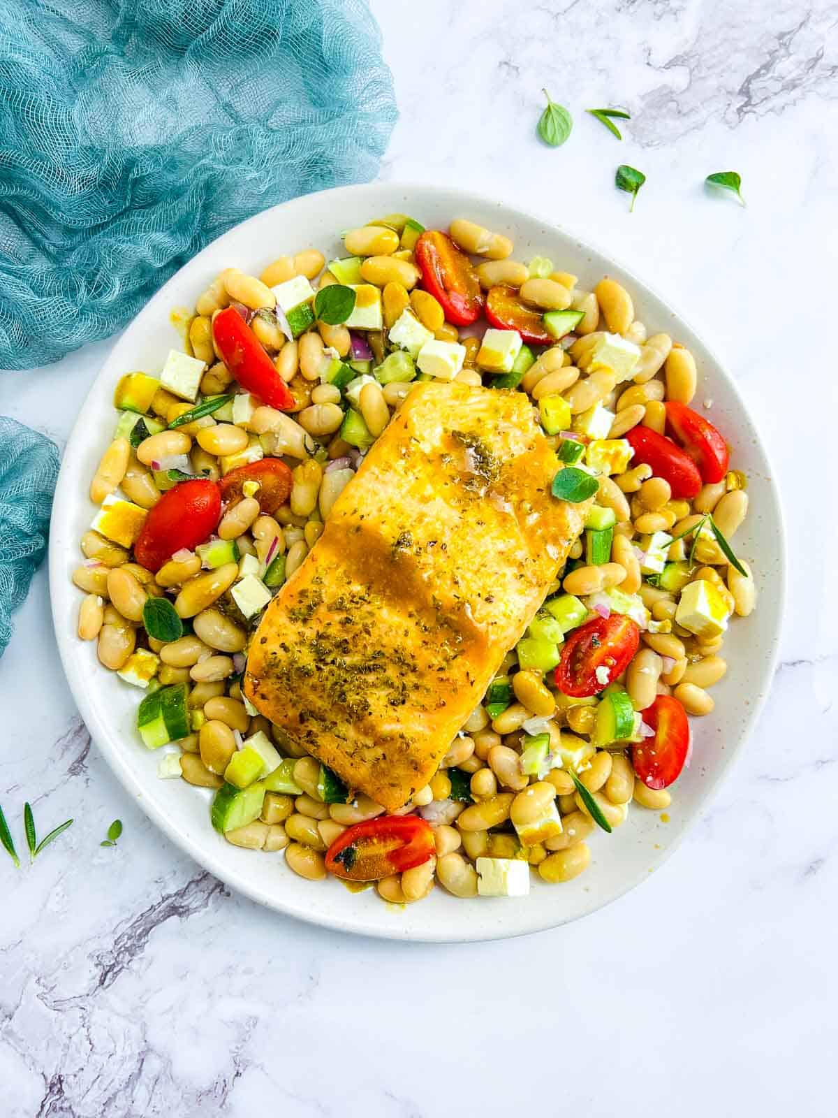 Salmon and white bean salad on a white serving plate.