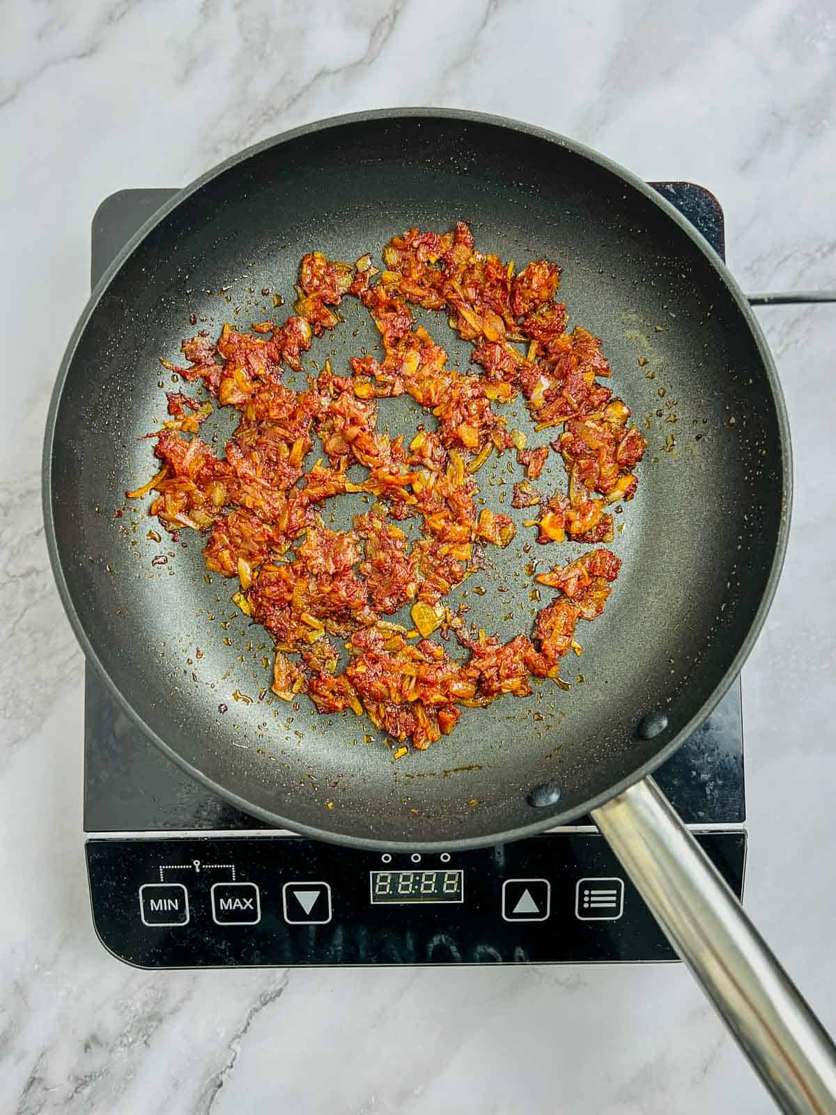 Sauted onion, garlic, and tomato paste in the skillet.