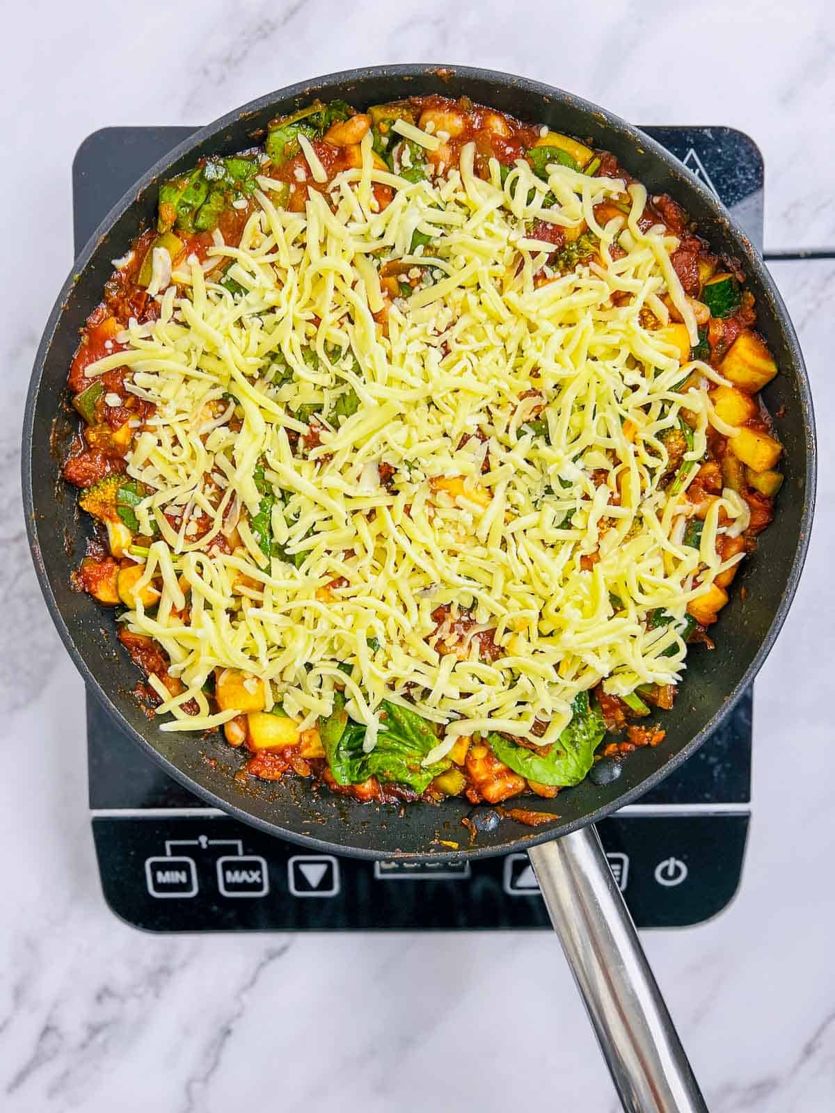 Cheese topping over the veggies and beans before baking in the oven.