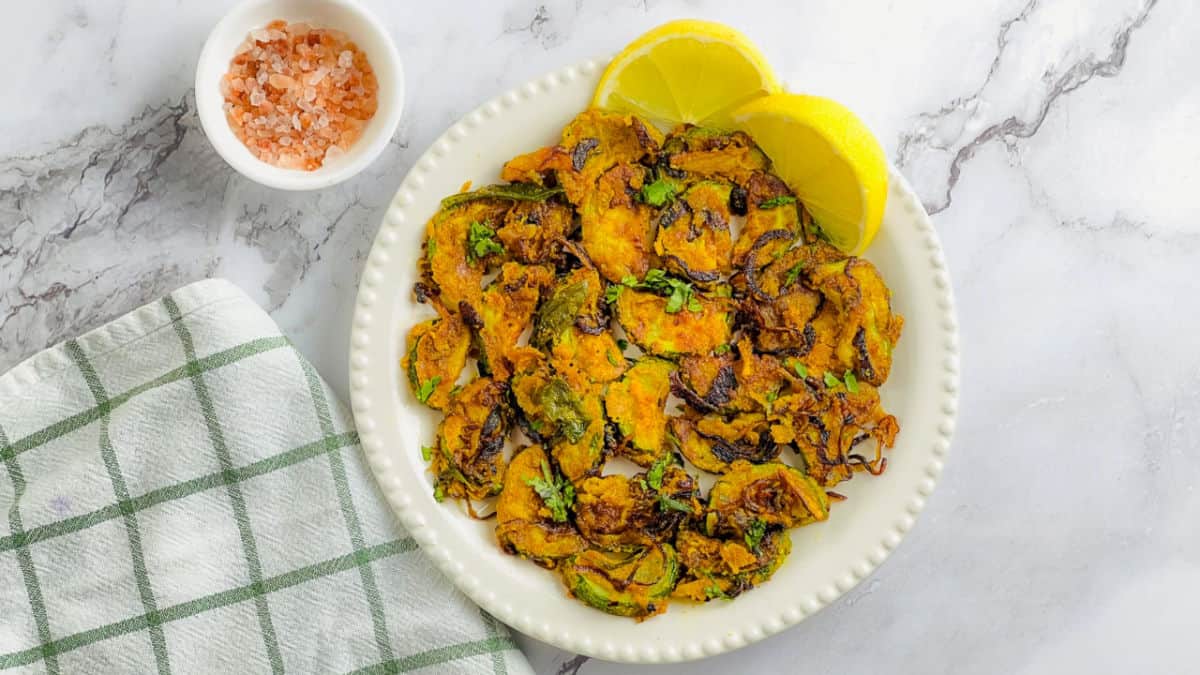Zucchini and chickpea flour stir fry with lemon wedges.