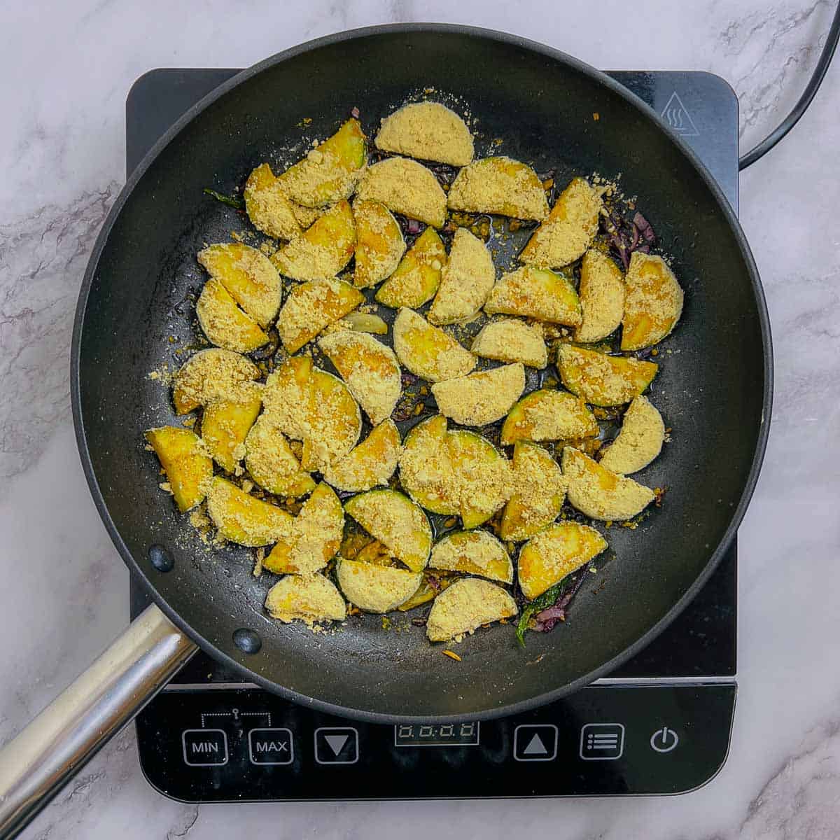 Zucchini slices added to the pan.