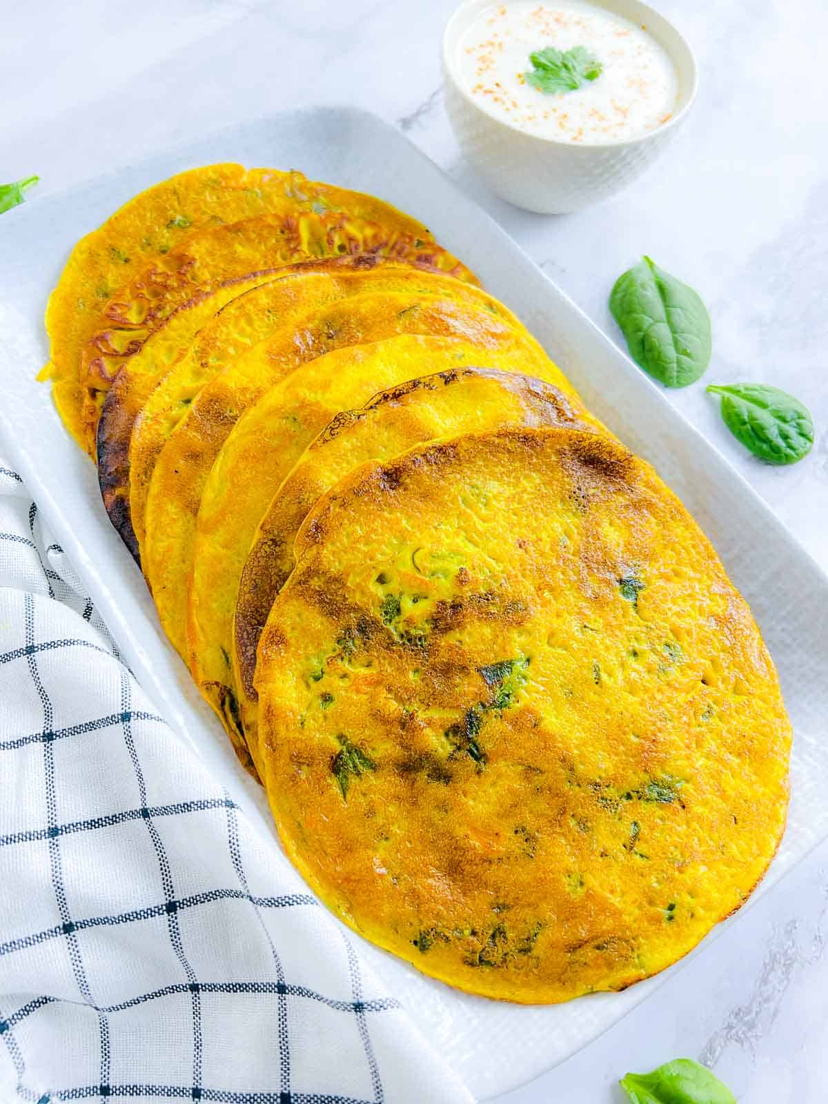 Chickpea flour pancakes on a white plate.