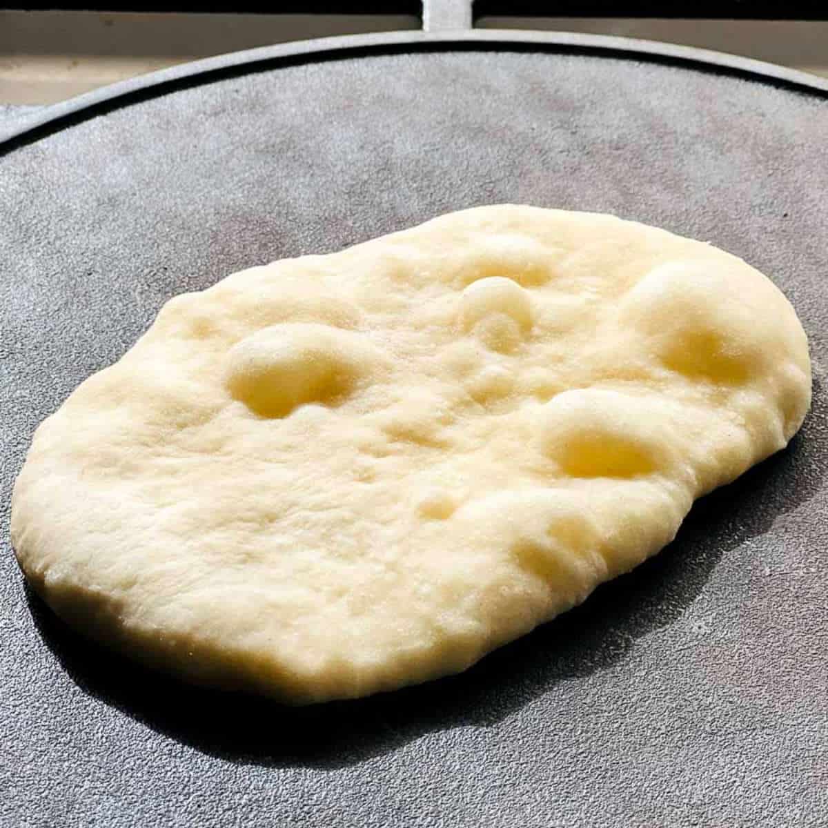 Naan cooked on a cast iron skillet.