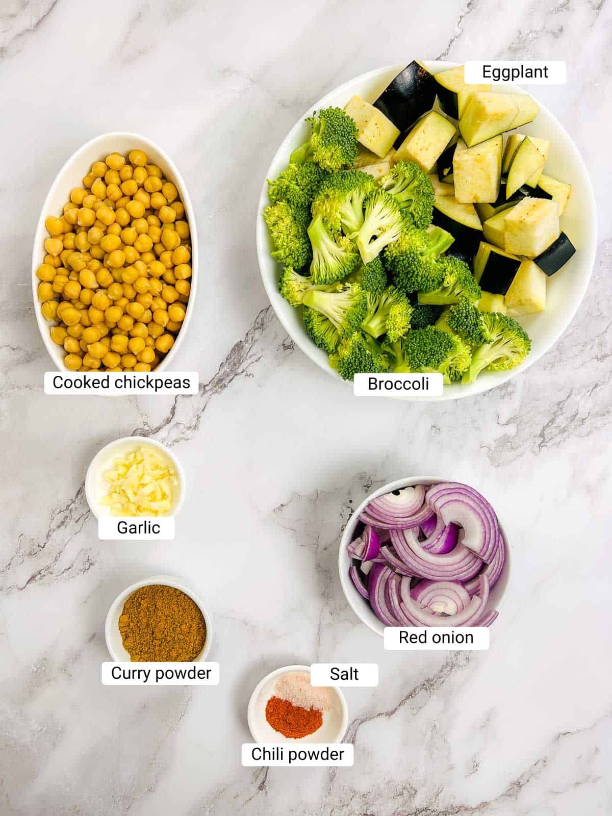 Ingredients to make roasted veggies on a marble surface.