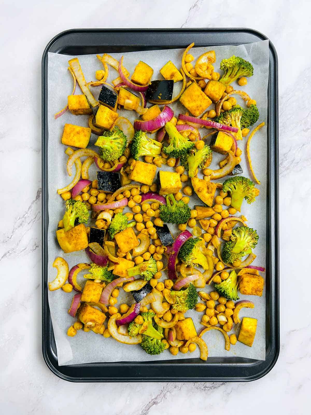 Season the veggies and chickpeas, and spread on a baking sheet.