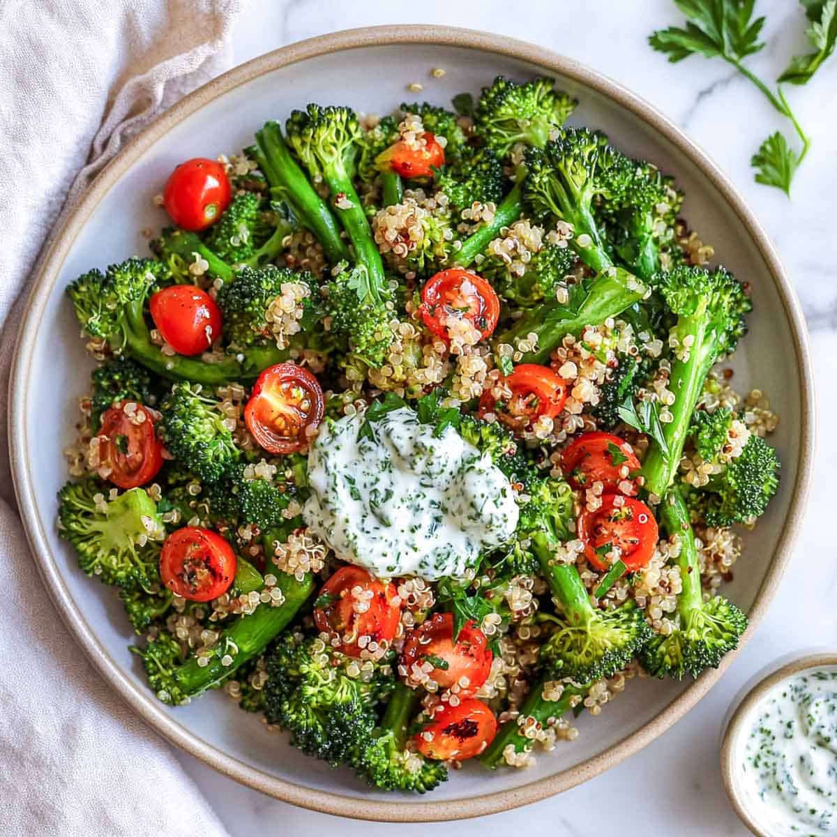 Broccolini quinoa salad topped with herbed yogurt.