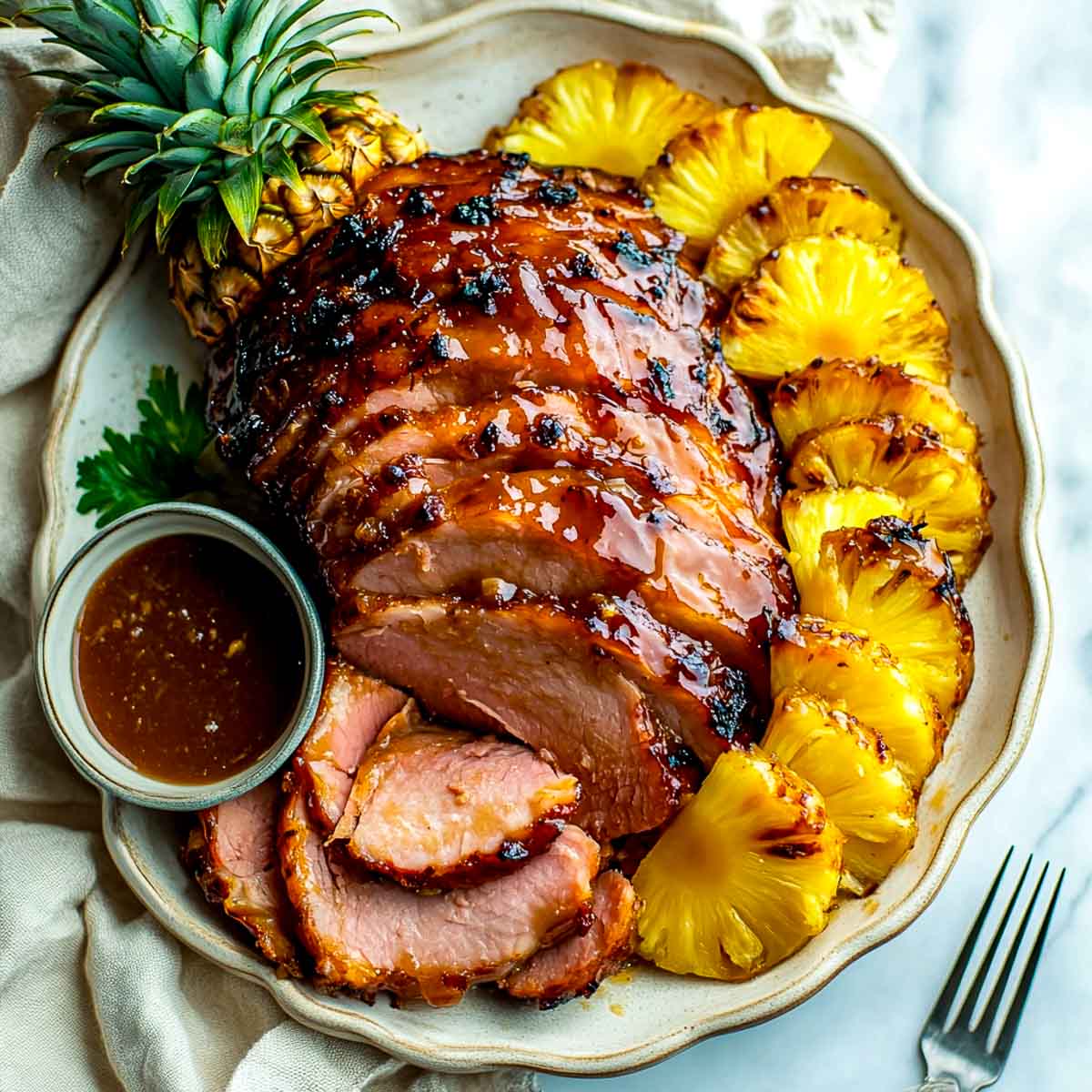 Brown sugar pineapple ham served on a white plate.