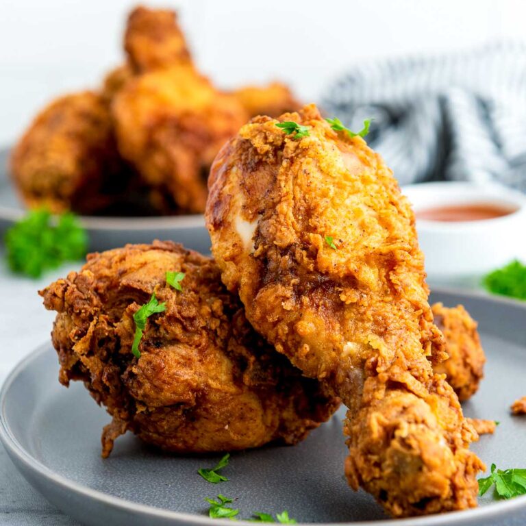 Buttermillk fried chicken garnished with parsley and served with dipping sauce.