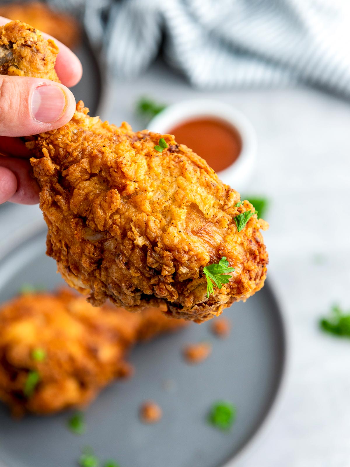Woman holding a fried chicken drumstick.