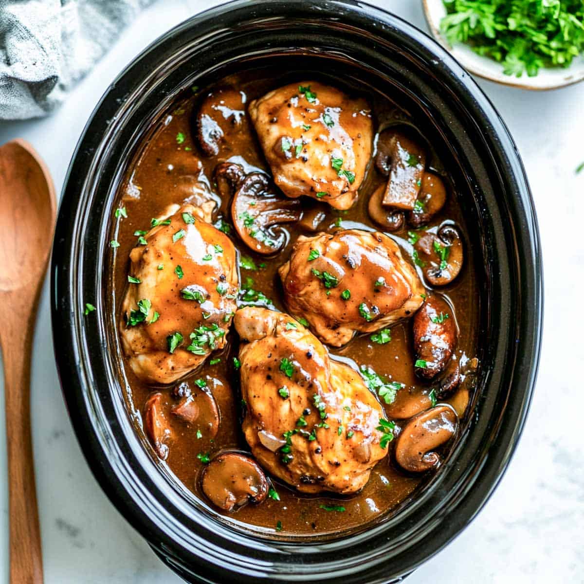 Crockpot chicken marsala on a white marble surface.