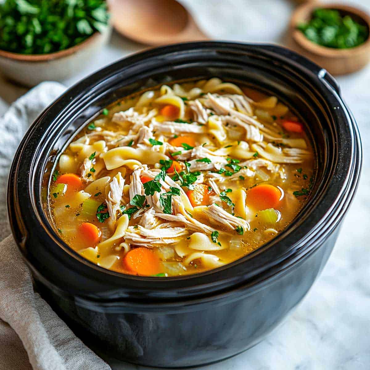 Side view of chicken noodle soup in crockpot.