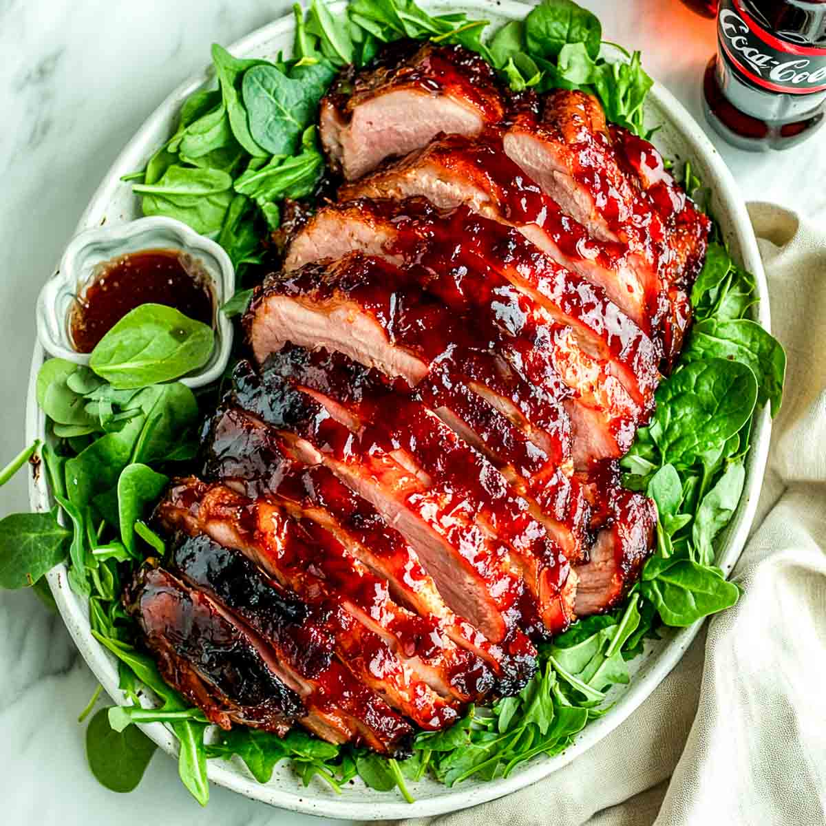 Coca cola ham served on a bed of greens.