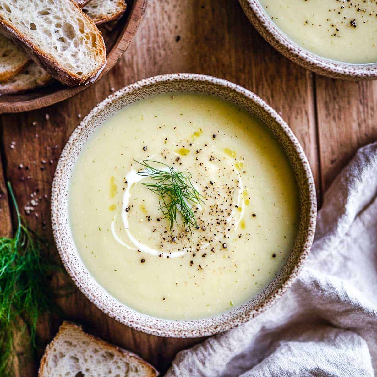 Fennel parsnip soup garnished with fennel and served with bread.