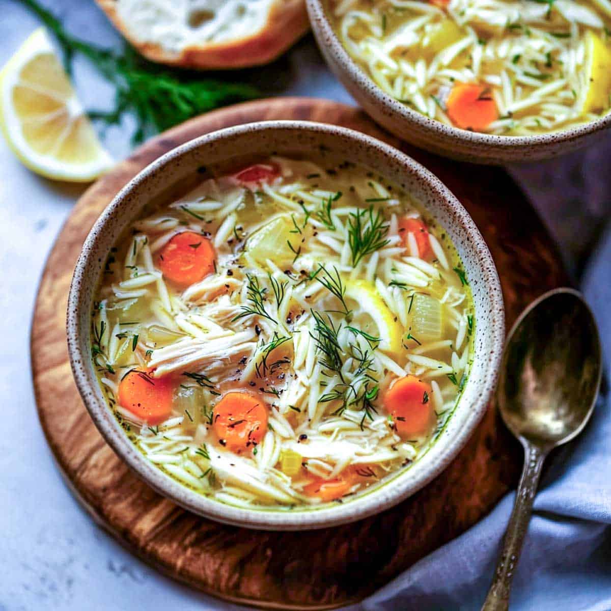 Two bowls of lemon chicken orzo soup.