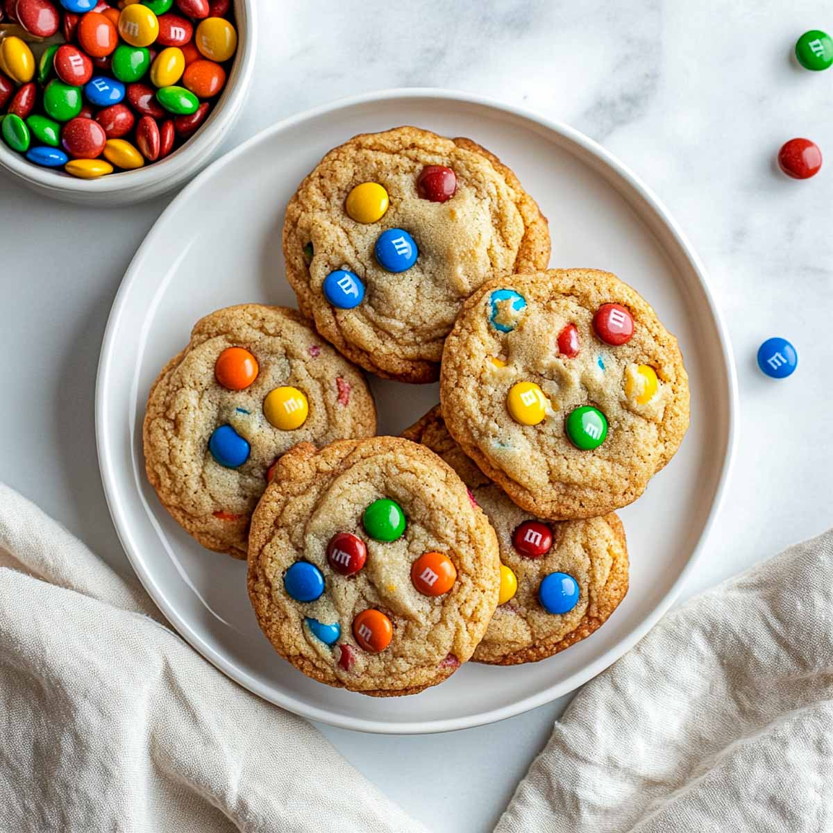 M&M cookies plate on a marble surface.