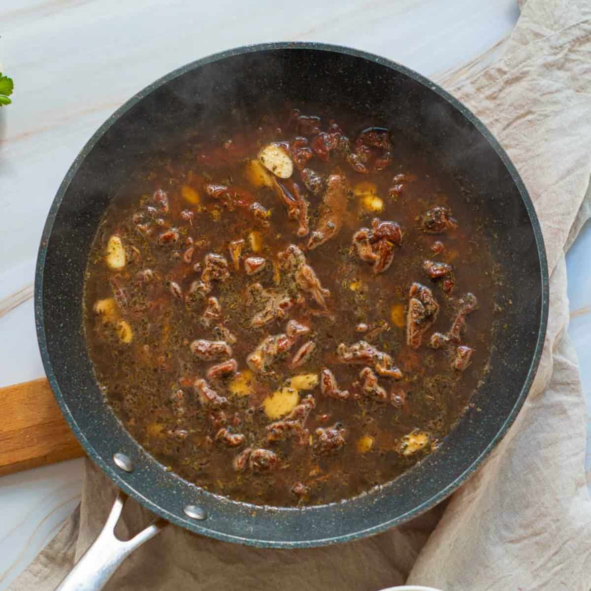 Sun-dried tomatoes and garlic sauce in the skillet.