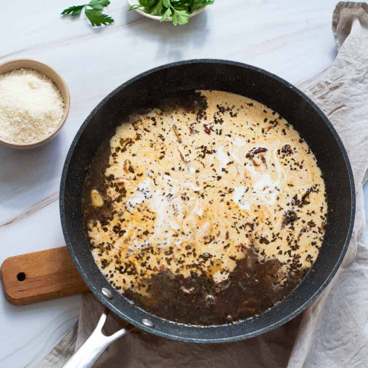 Heavy cream and cheese added to the skillet.