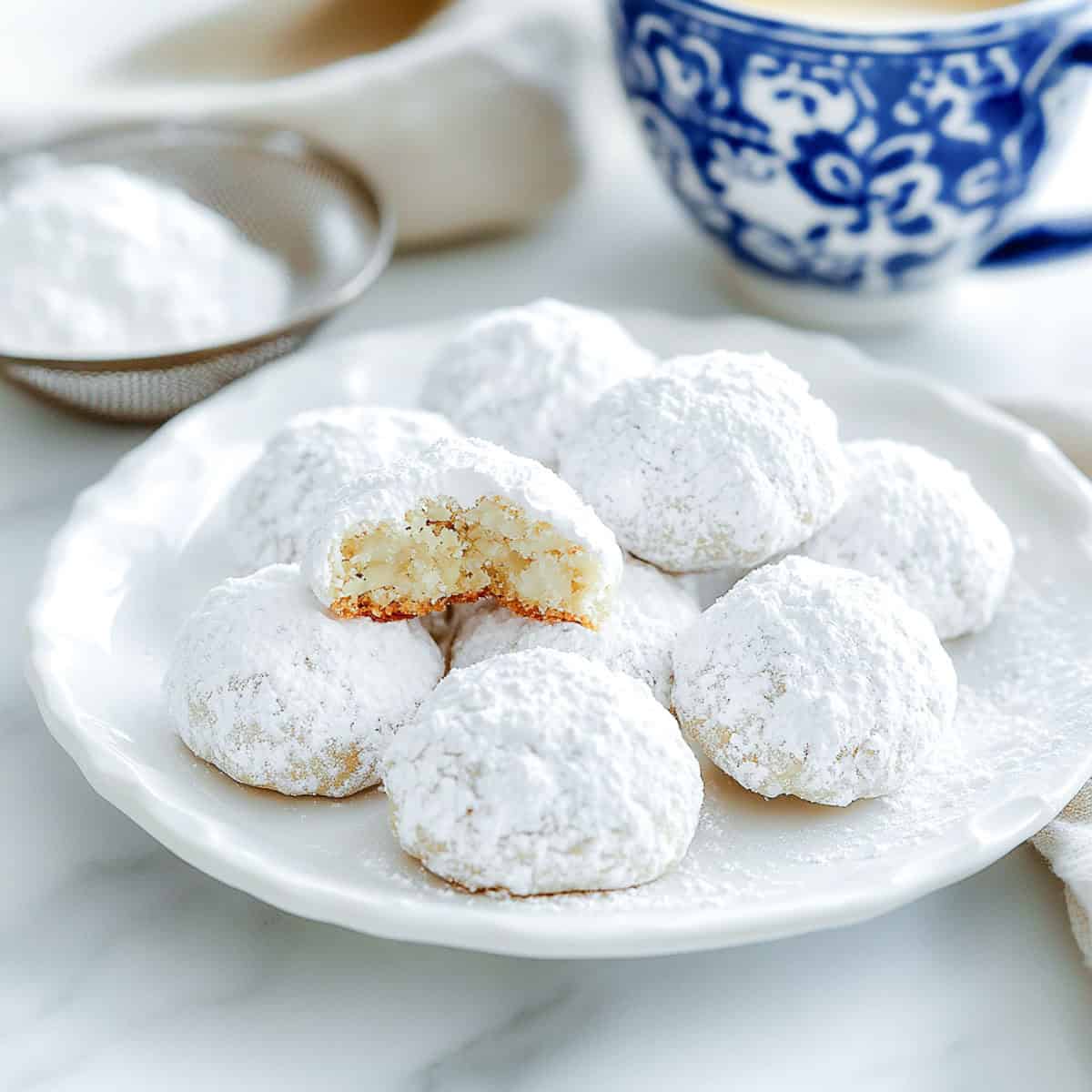 A plate of Mexican wedding cookies on a serving plate.