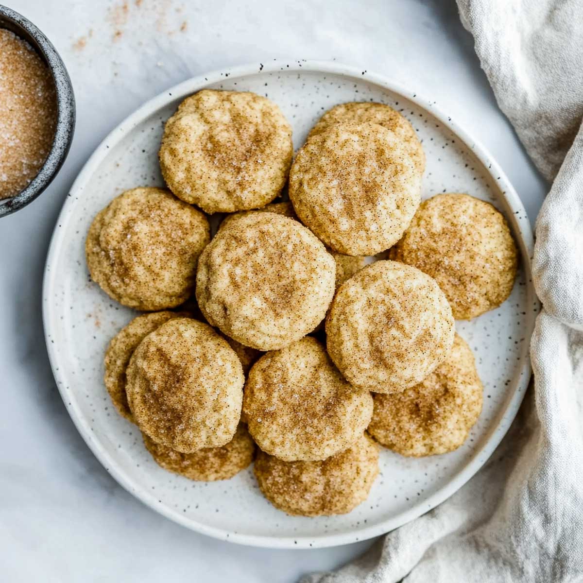 A plate of snickerdoodles on a marble surface.
