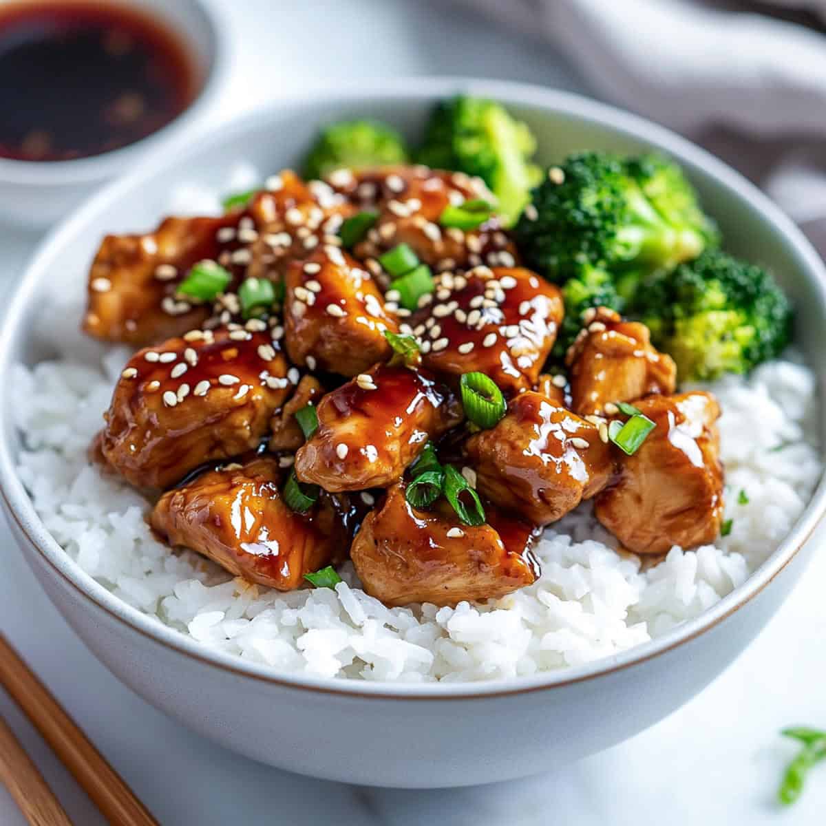 Teriyaki chicken served with rice and steamed broccoli in a bowl.