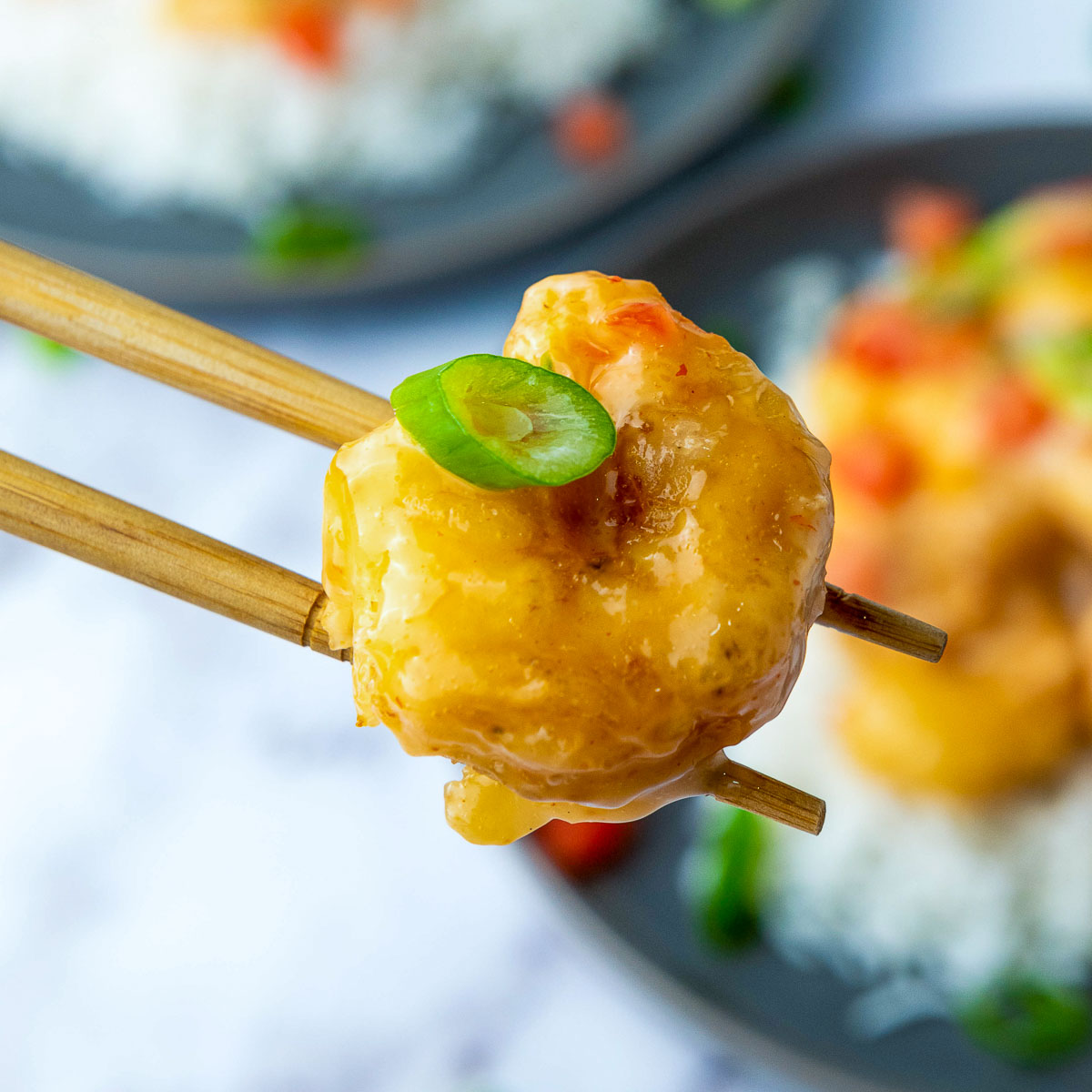 A bang bang shrimp picked using chopsticks.
