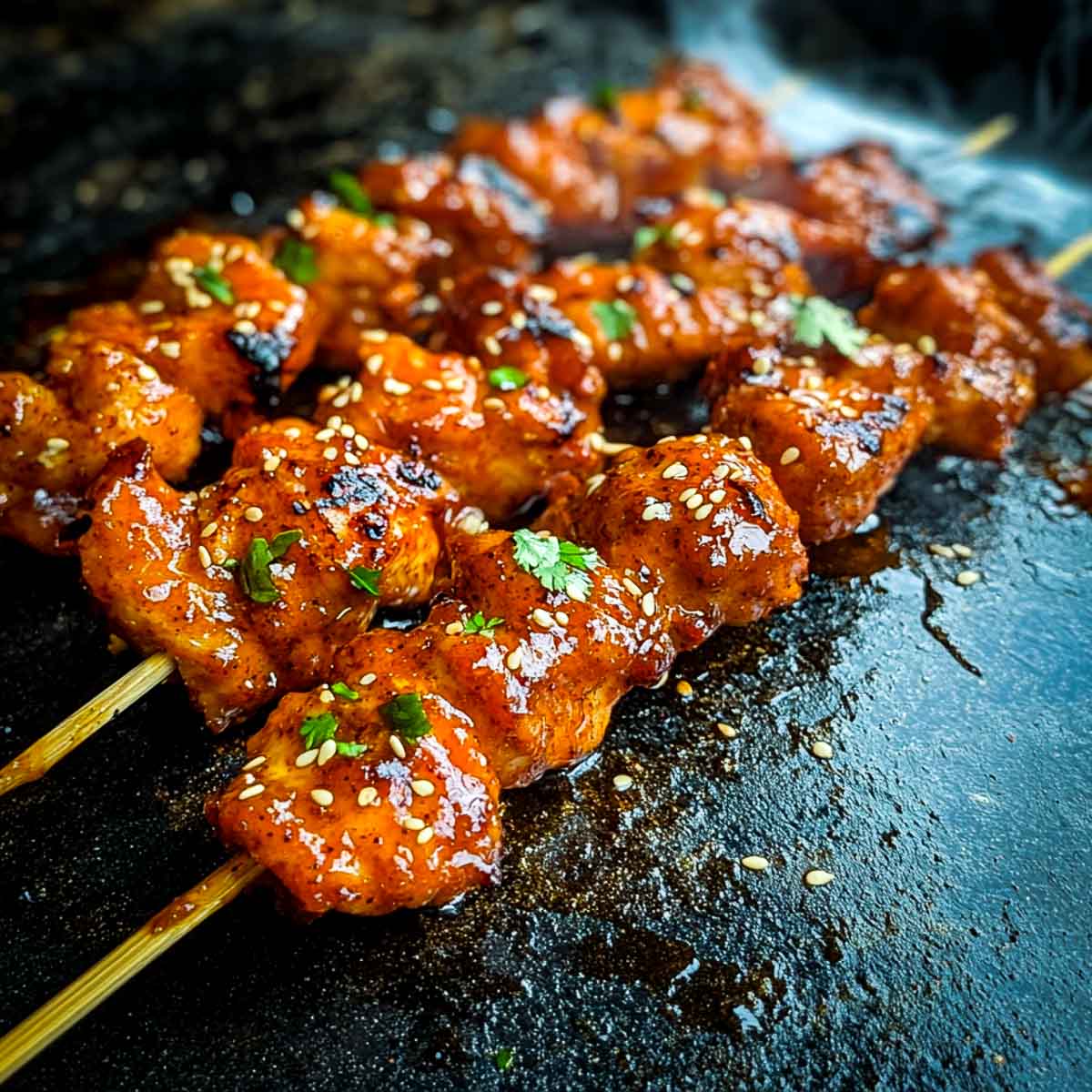 Chicken skewers threaded into wooden skewers.