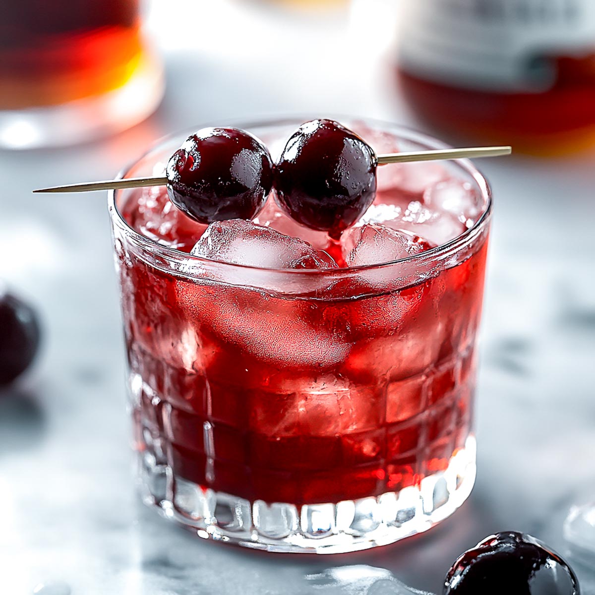 Cherry smash bourbon cocktail in a rocks glass.