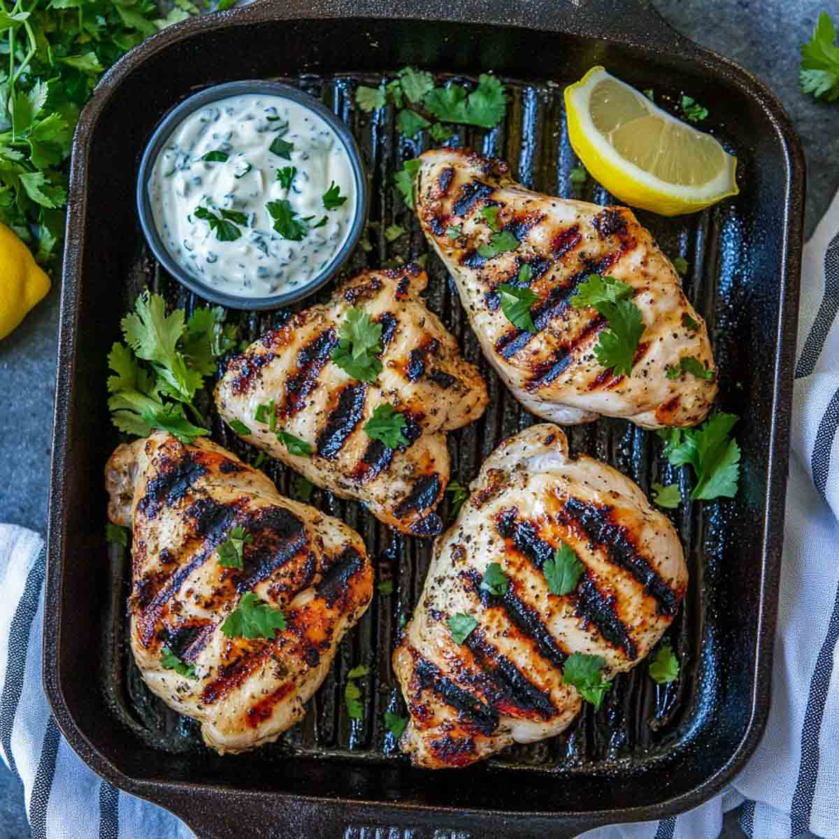 Grilled chicken breast in Greek yogurt marinade on a grill.