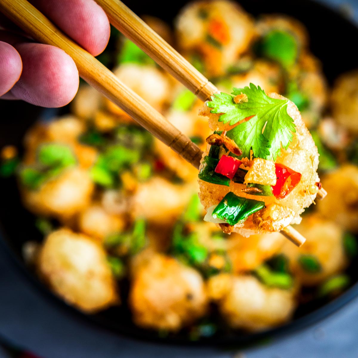 Close up view of shrimp picked using chopsticks.