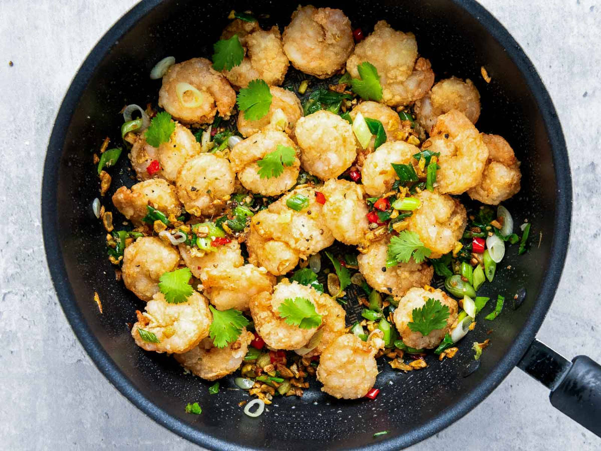 Shrimp tossed in the skillet and topped with crushed pepper and coarse salt.
