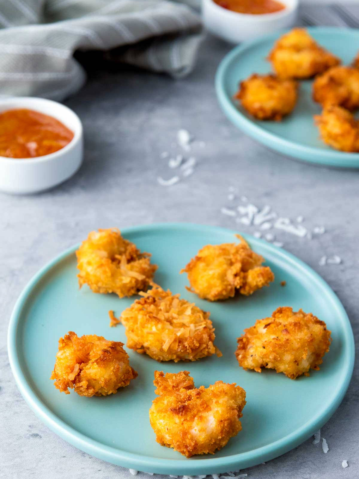 Side view of coconut shrimp on a blue plate.