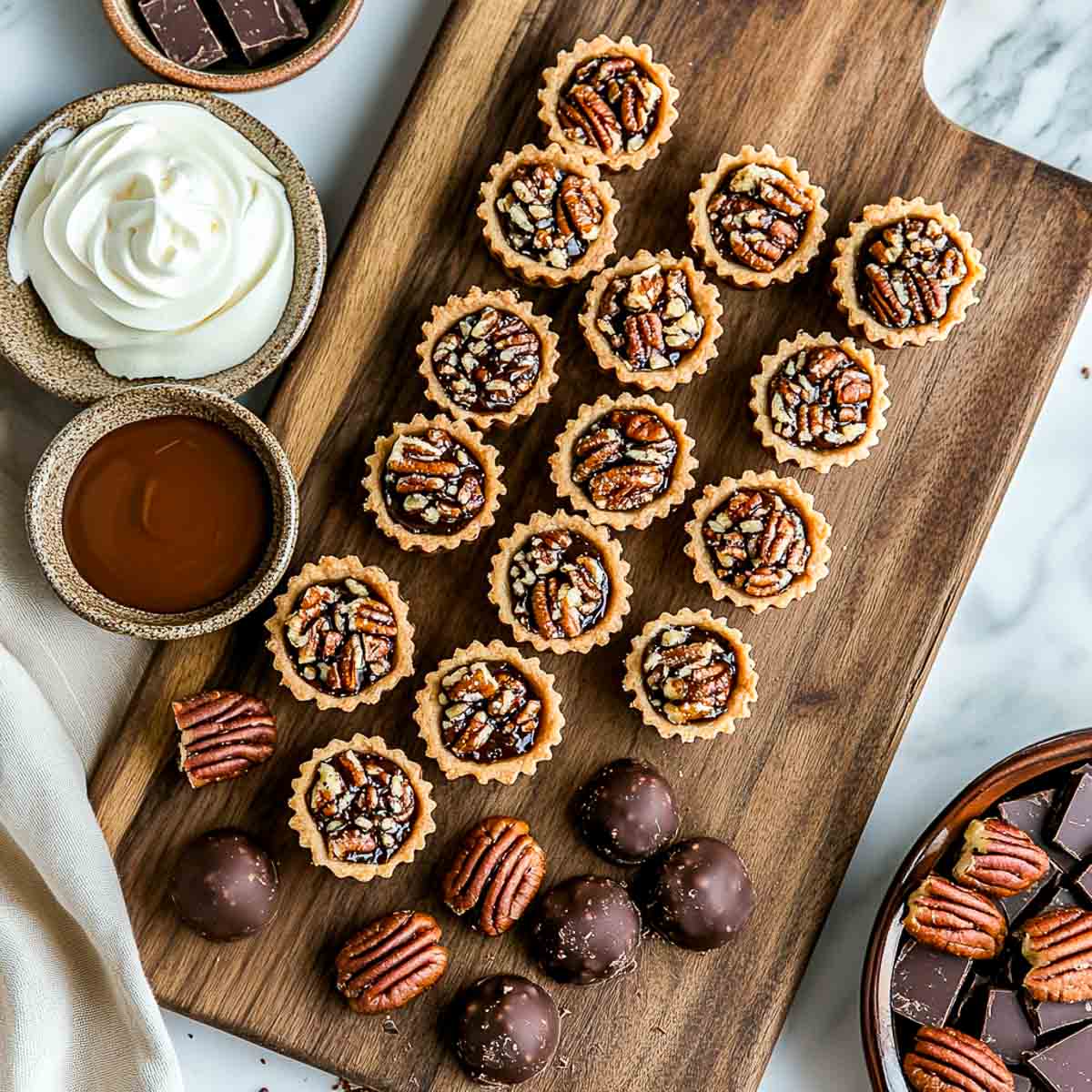 Mini pecan pies and chocolate bourbon balls served with whipped cream and chocolate sauce.