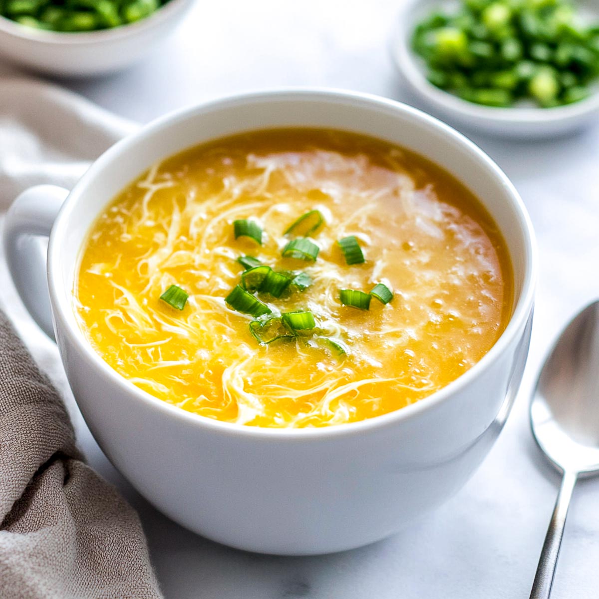 Egg drop soup topped with green onions.