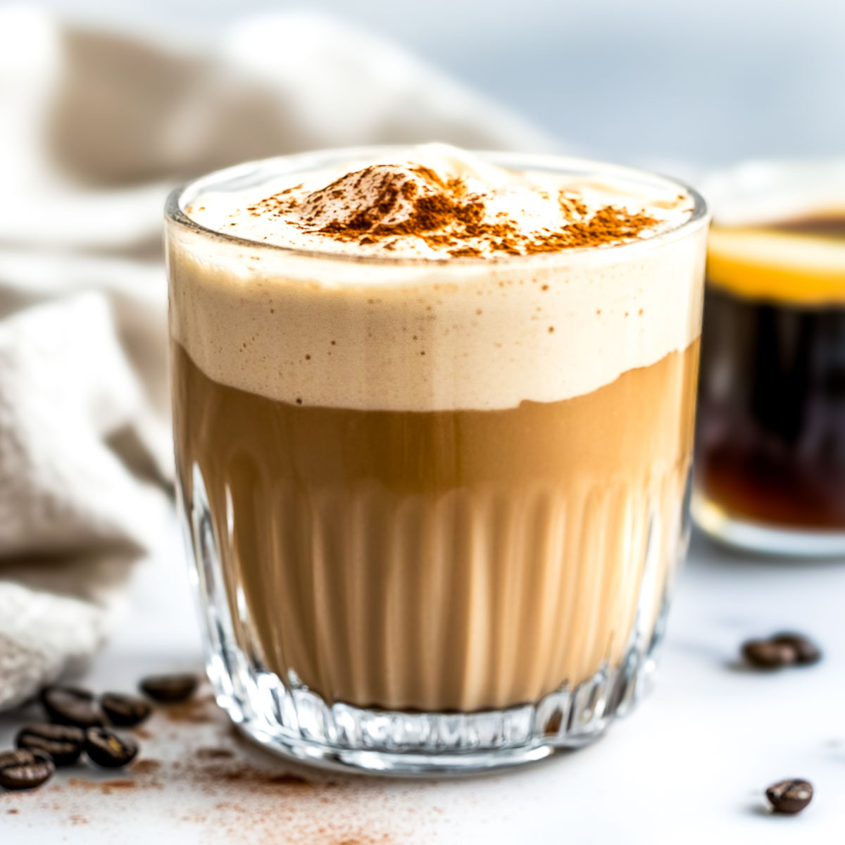 Espresso protein shake with an espresso shot in the background.