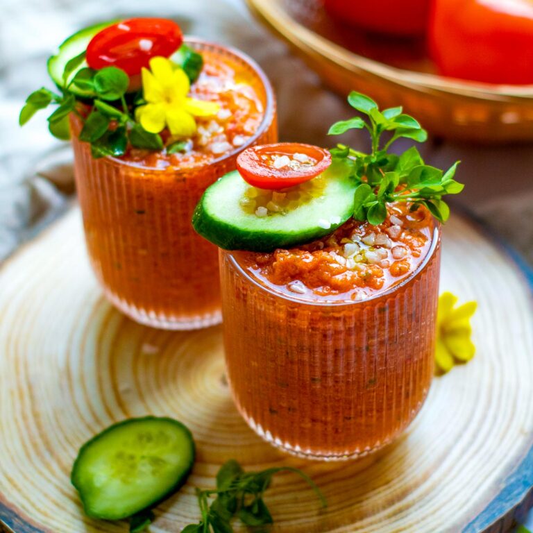 Two shots of gazpacho topped with microgreens.