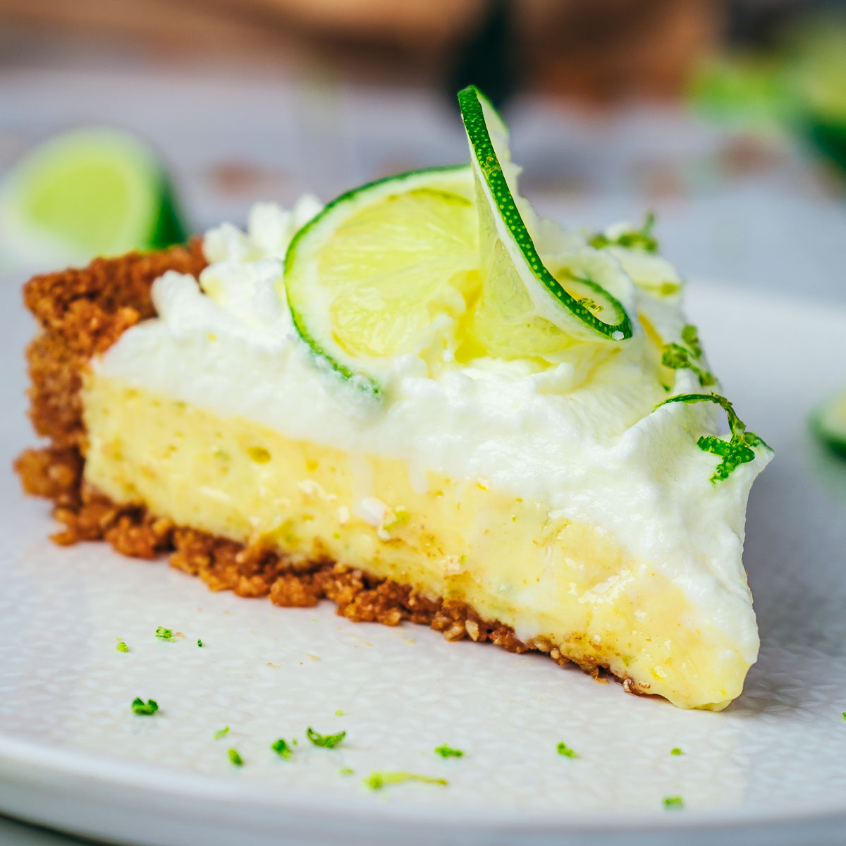 Close up of a slice of key lime pie crust on a white plate.