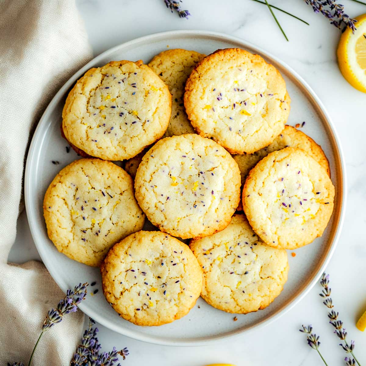 Lemon lavender cookies on a plate placed on a white marble surface.