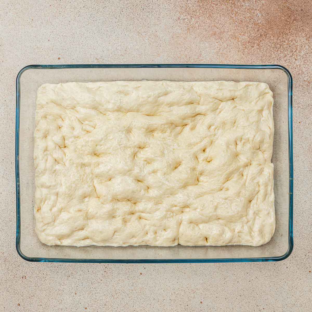 Spread the dough and make dimples.
