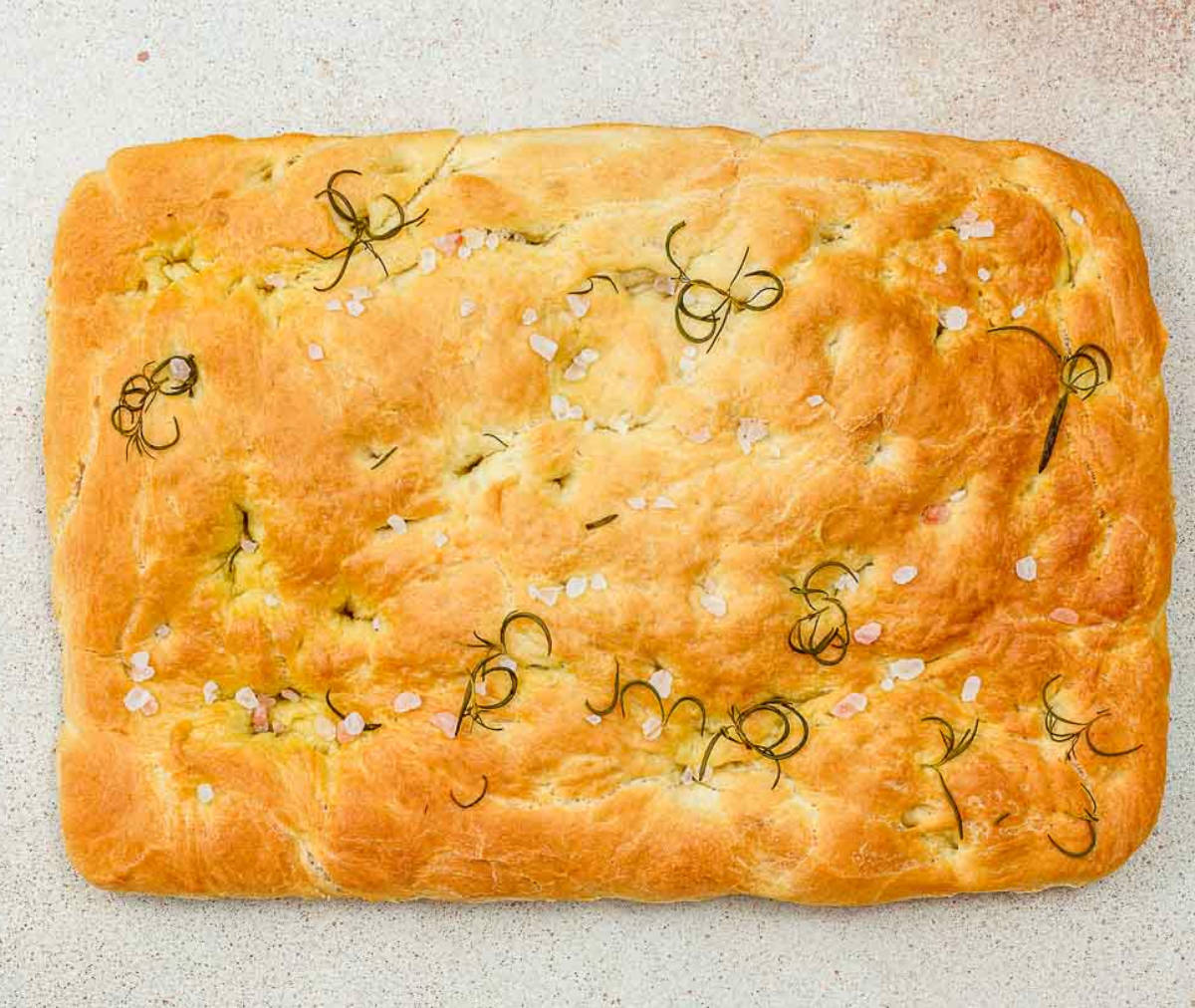 Perfectly baked rosemary focaccia on a board.