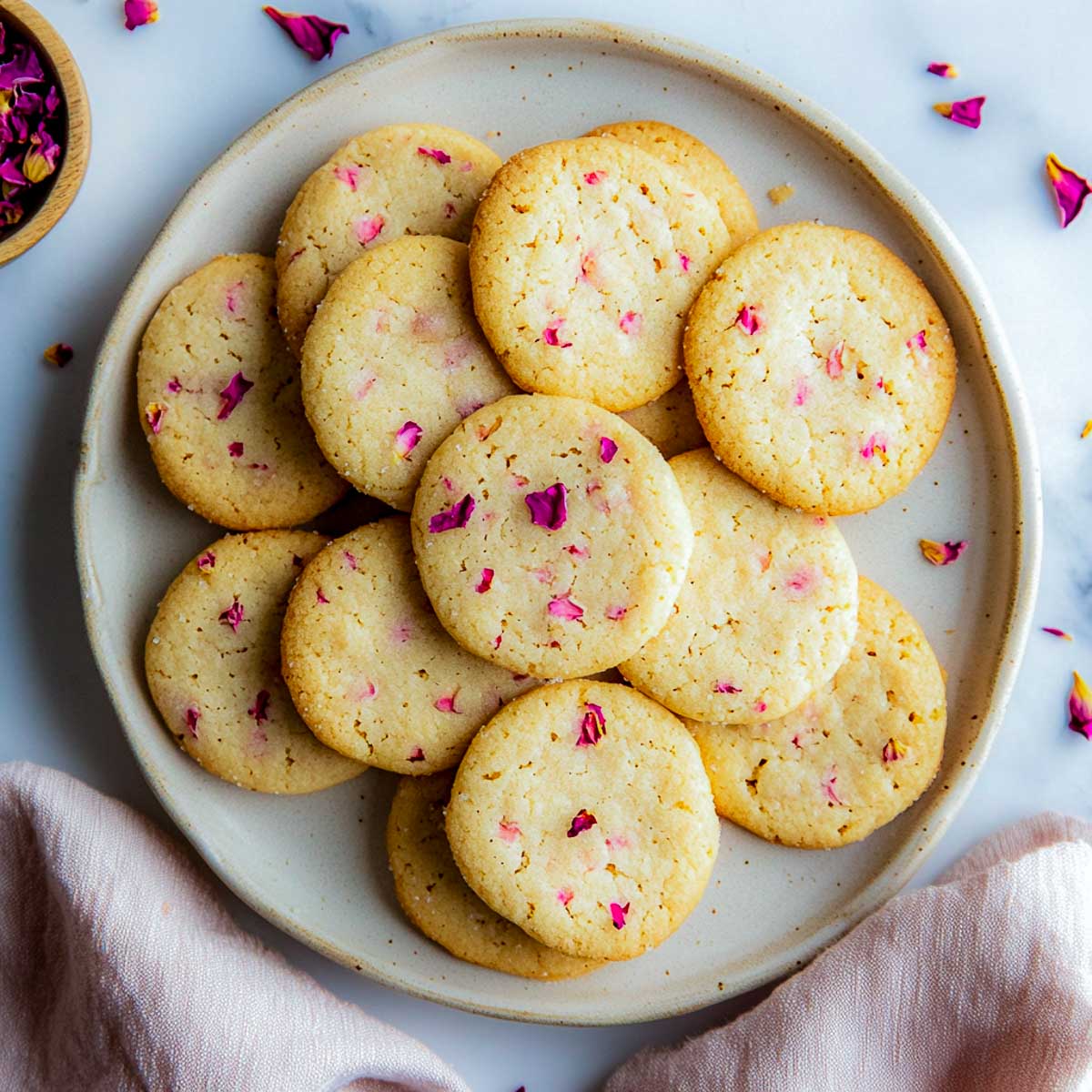 Top view of rosewater cookies on a grey plate.