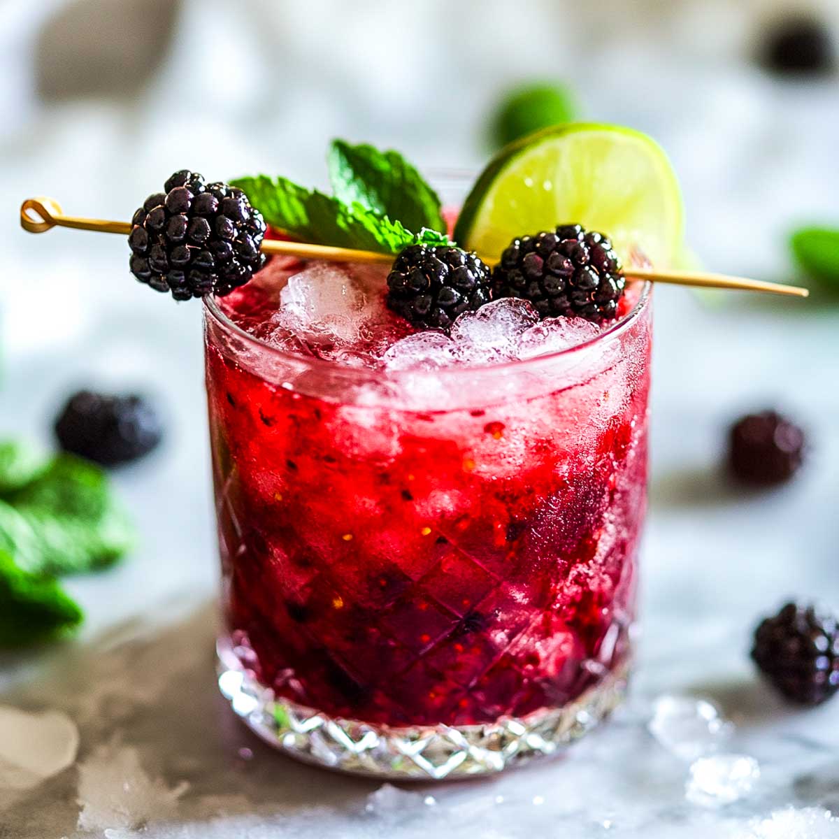 Spring berry smash in a rocks glass placed on a marble surface.