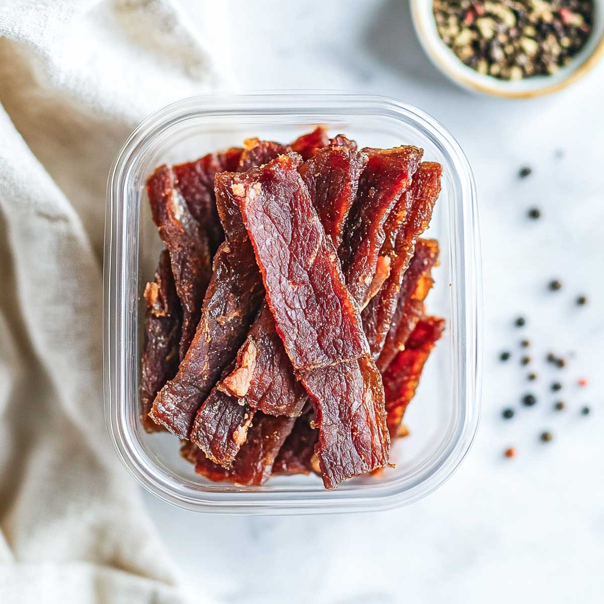 Turkey jerky in a box placed on a marble surface.