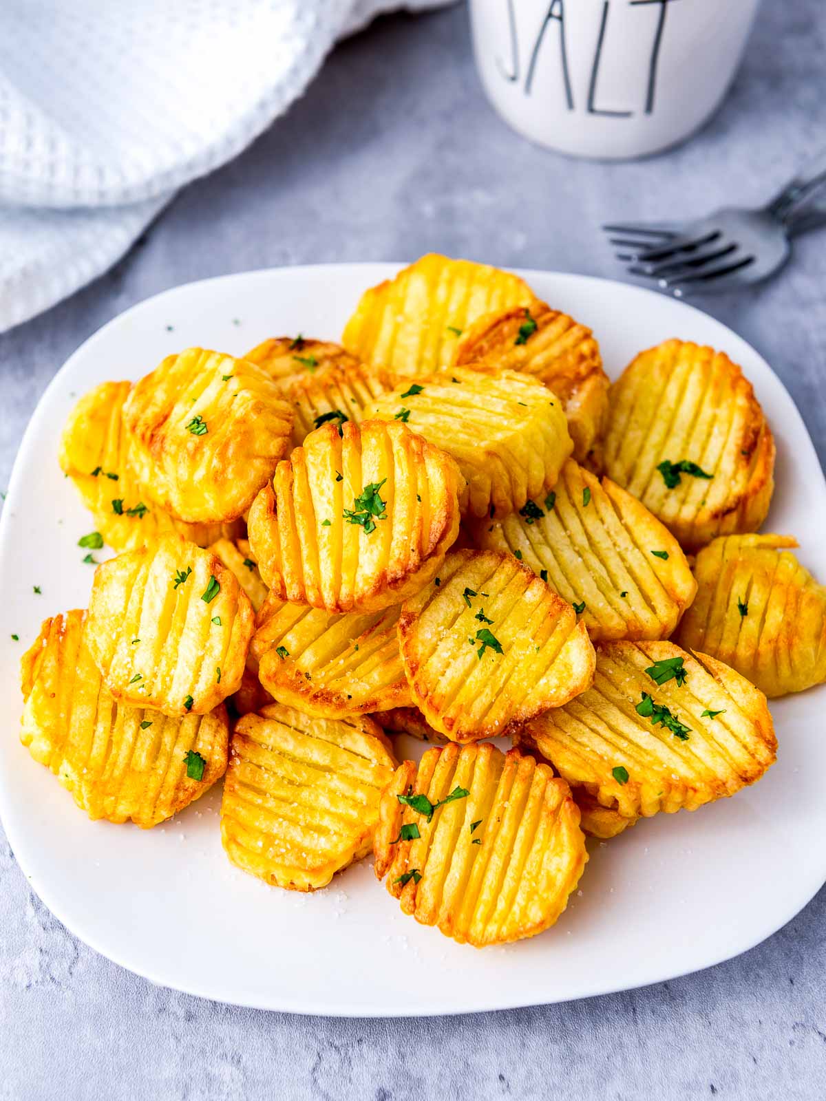 Air fryer accordion potatoes garnished with parsley.