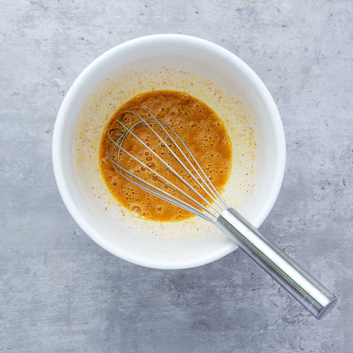 Egg batter whisked in a small mixing bowl.
