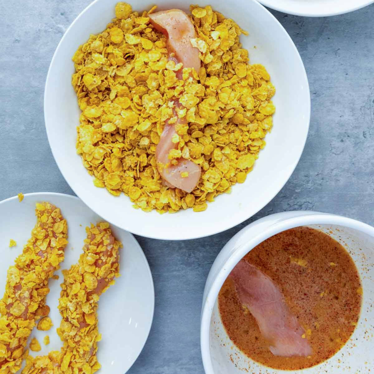 Chicken pieces coated in crushed cornflakes.