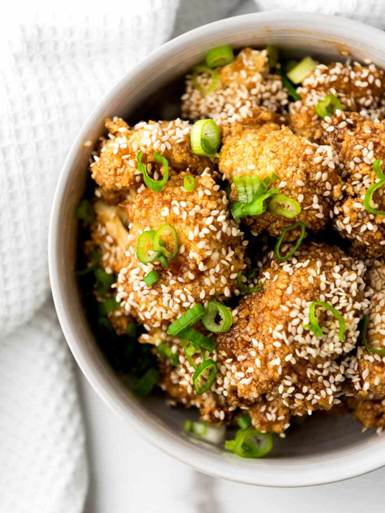 Close up of tariyaki cauliflower wings placed on a marble surface.