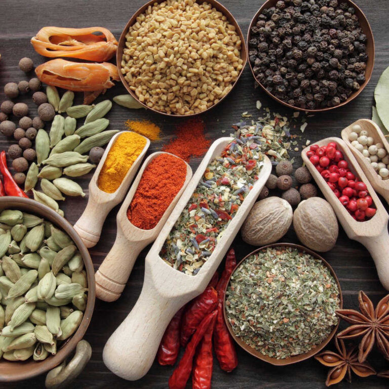 Several varieties of spices on a wooden surface.
